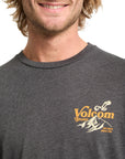Man wearing a dark gray Volcom t-shirt with a logo on a white background
