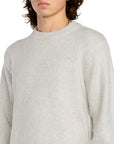 Person wearing a light gray sweater on a white background
