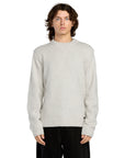 Person wearing a light gray sweater on a white background