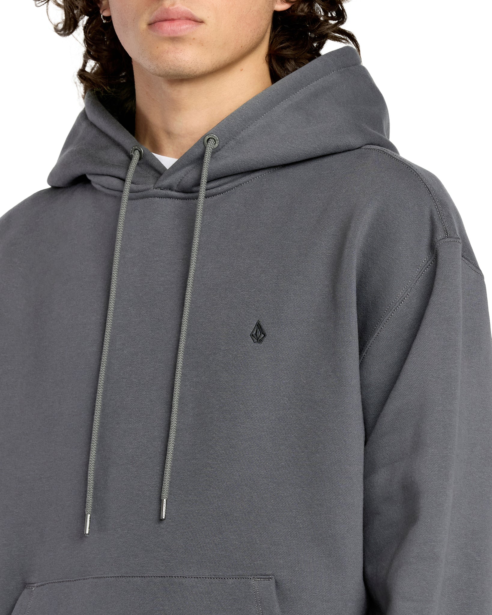 Person wearing a gray hoodie with a small logo on a white background