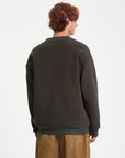 Person wearing a dark green sweatshirt on a white background
