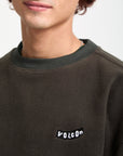 Person wearing a dark brown sweatshirt with Volcom logo