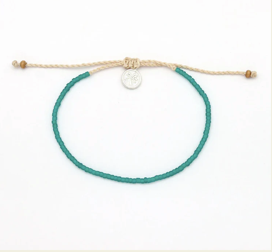 A beaded bracelet with a vibrant teal green cord and a beige adjustable sliding knot closure, featuring a small silver circular charm and wooden beads at the ends, shown on a plain white background.