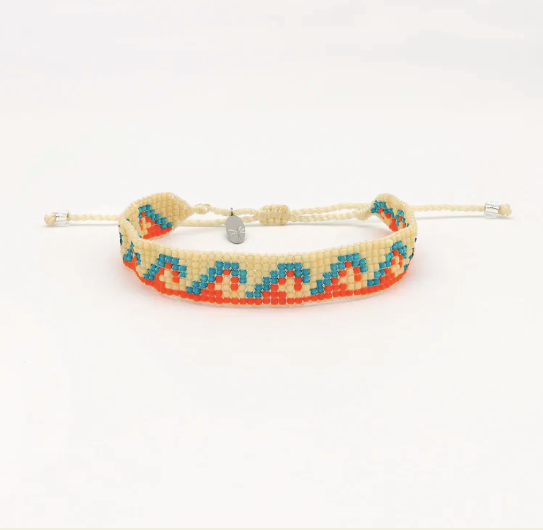 A beaded adjustable friendship bracelet with a cream-colored cord and a geometric pattern of orange, turquoise blue, and cream seed beads, featuring a small silver metal charm.