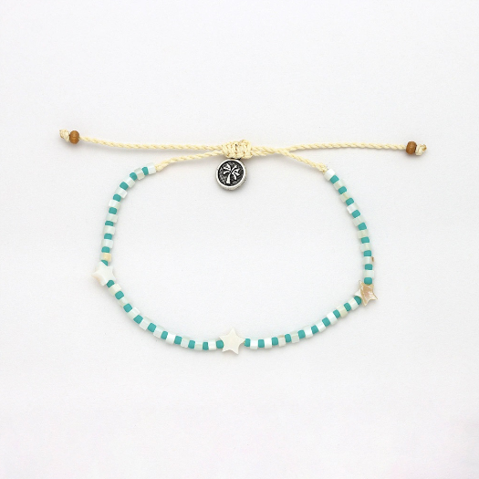 A beaded sliding cord bracelet featuring turquoise and white striped beads, white star charms, and a central silver-toned circular charm with a black design, displayed on a clean white background.