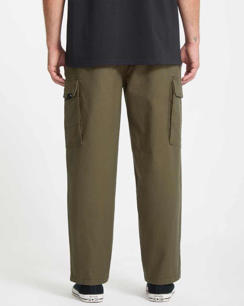 Person wearing olive green Volcom cargo pants on a white background