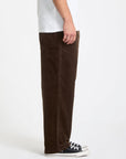 Brown corduroy pants worn by a person on a white background