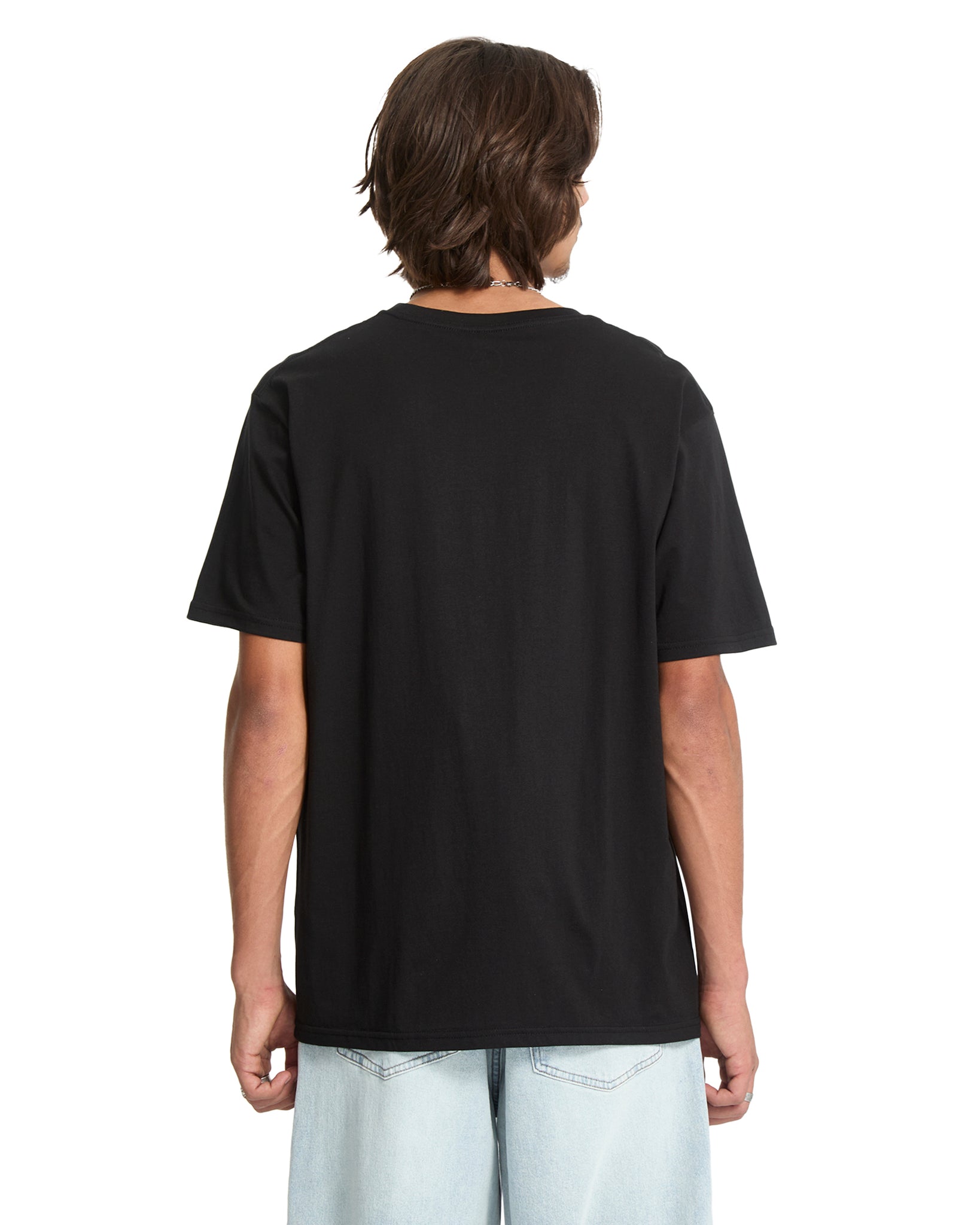Person wearing a black Volcom  t-shirt on a white background