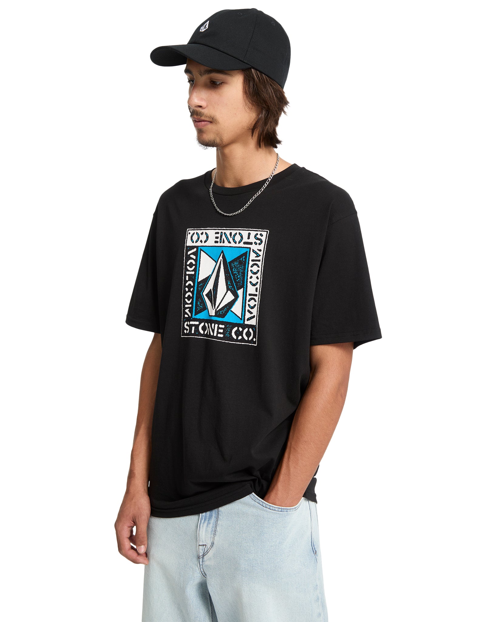 Person wearing a black t-shirt with a logo and a black cap on a white background