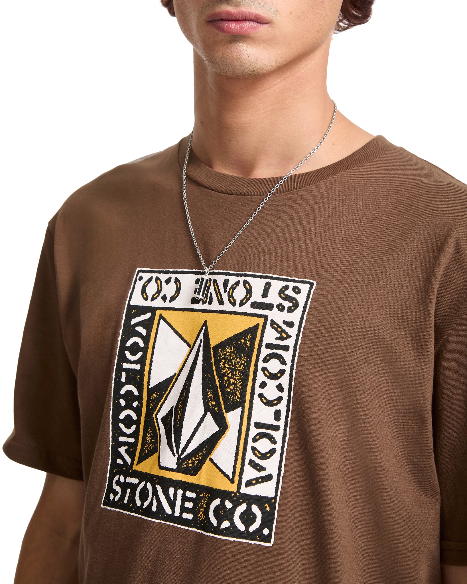 Person wearing a brown t-shirt with a Volcom logo