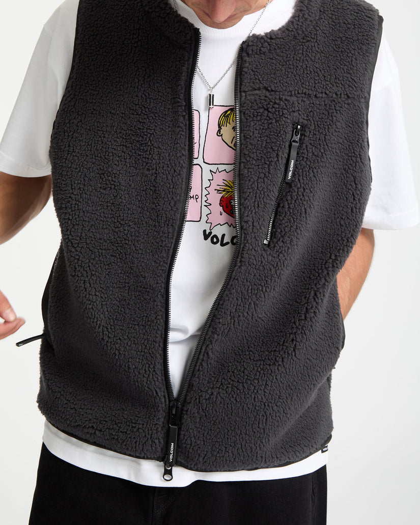 Person wearing a black fleece vest over a white shirt with graphic design