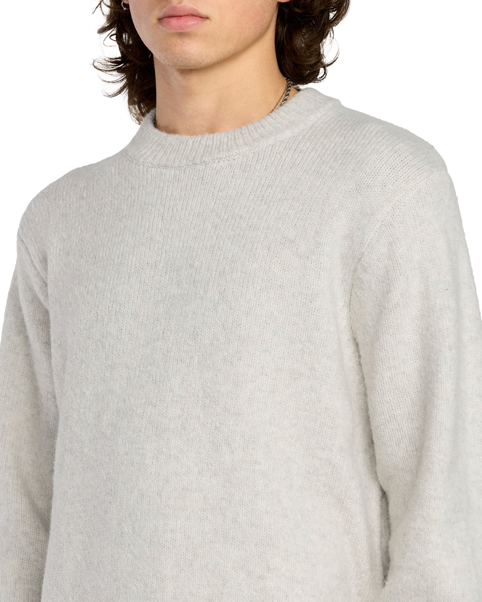 Person wearing a light gray sweater on a white background