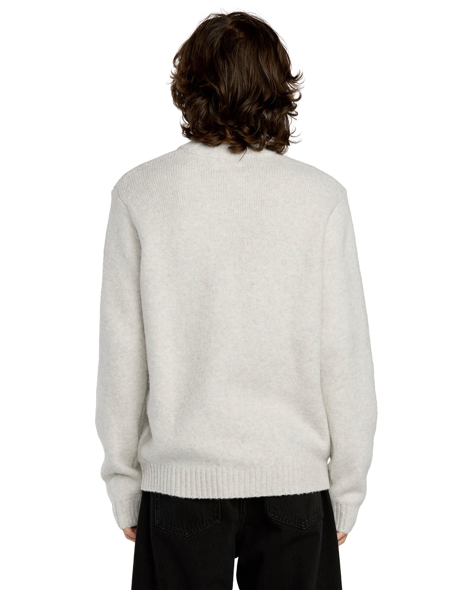 Person wearing a light gray sweater on a white background