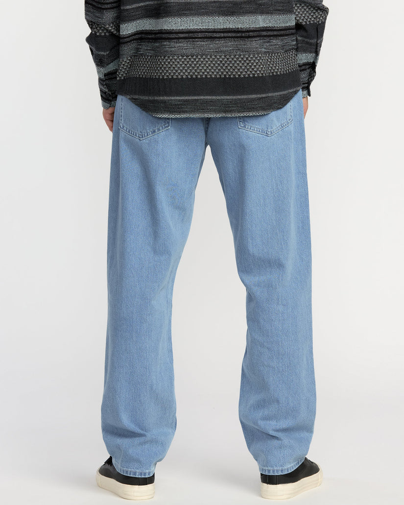 Person wearing blue jeans and a patterned sweater on a white background