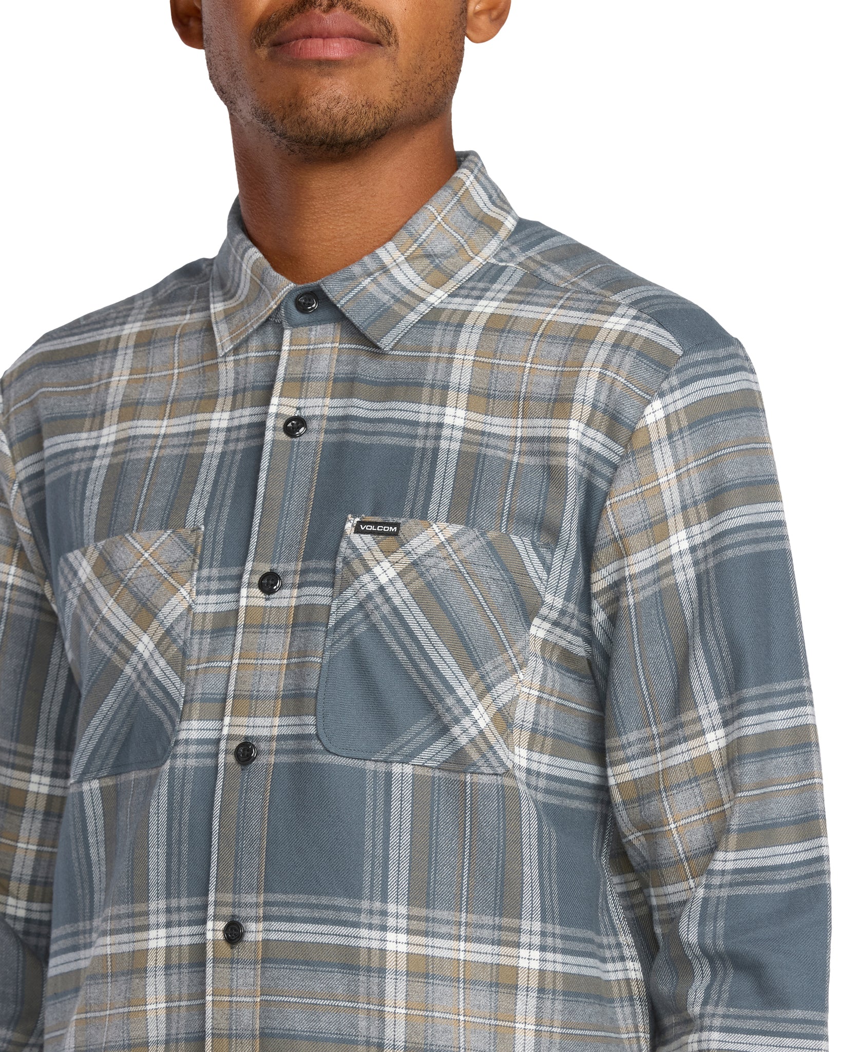 Man wearing a Volcom plaid shirt with a visible brand logo on a white background, available at Mango Surfing.