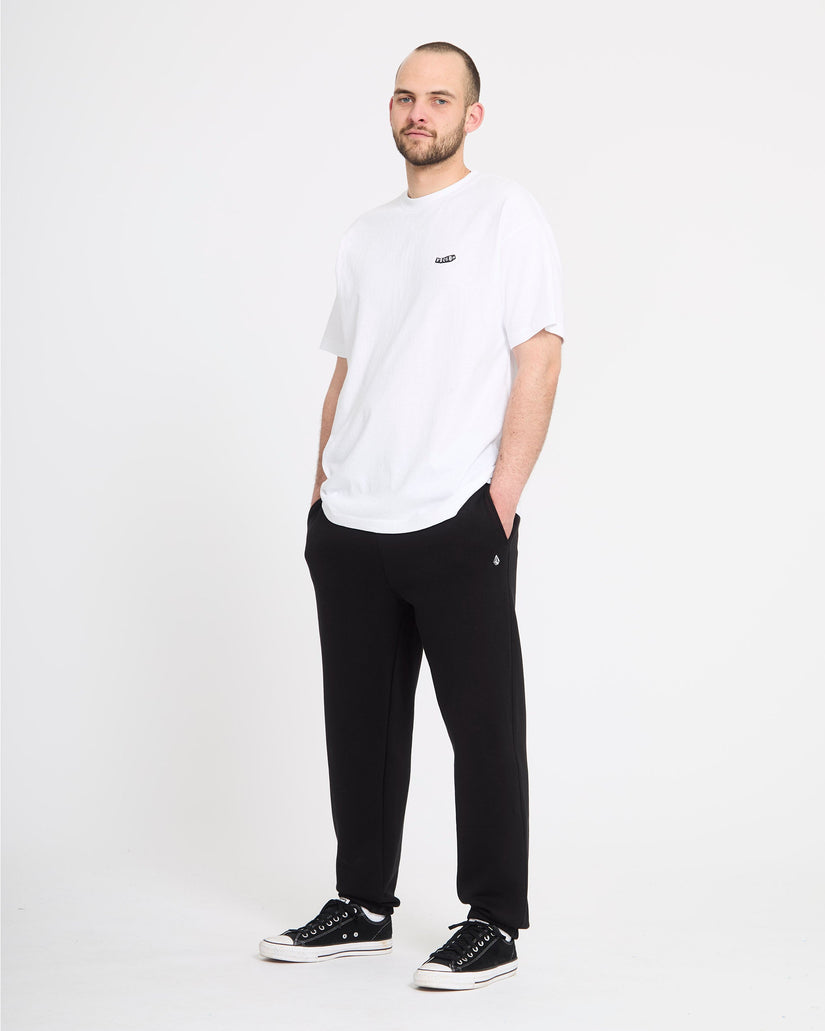 Man wearing a white t-shirt and black pants on a white background