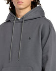 Person wearing a gray hoodie with a small logo on a white background
