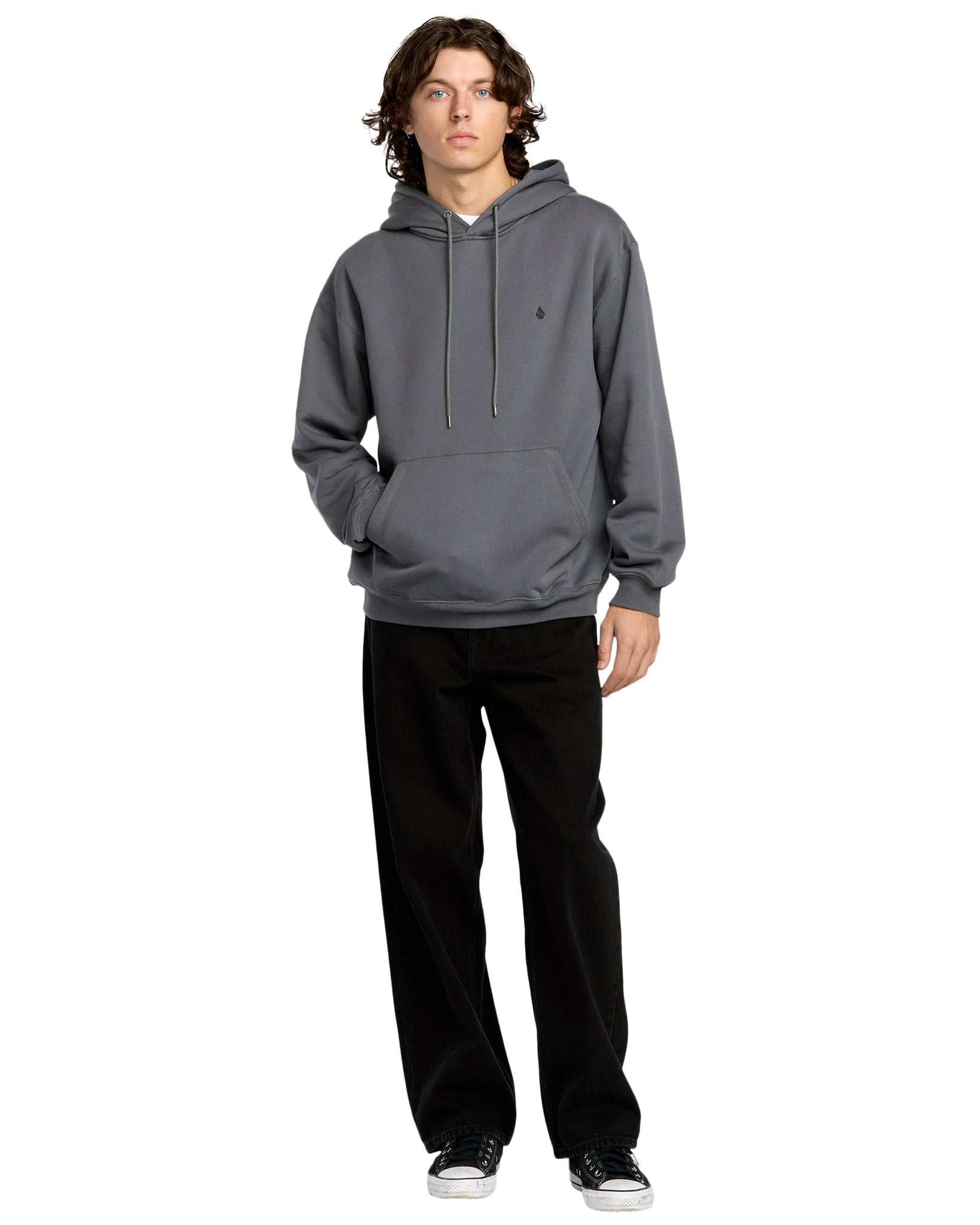 Person wearing a gray hoodie and black pants on a white background