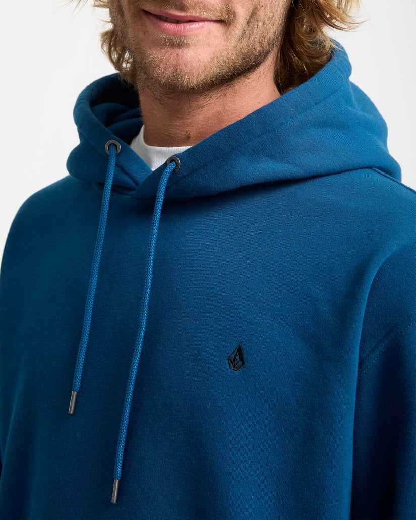 Person wearing a blue hoodie with a small logo on a white background