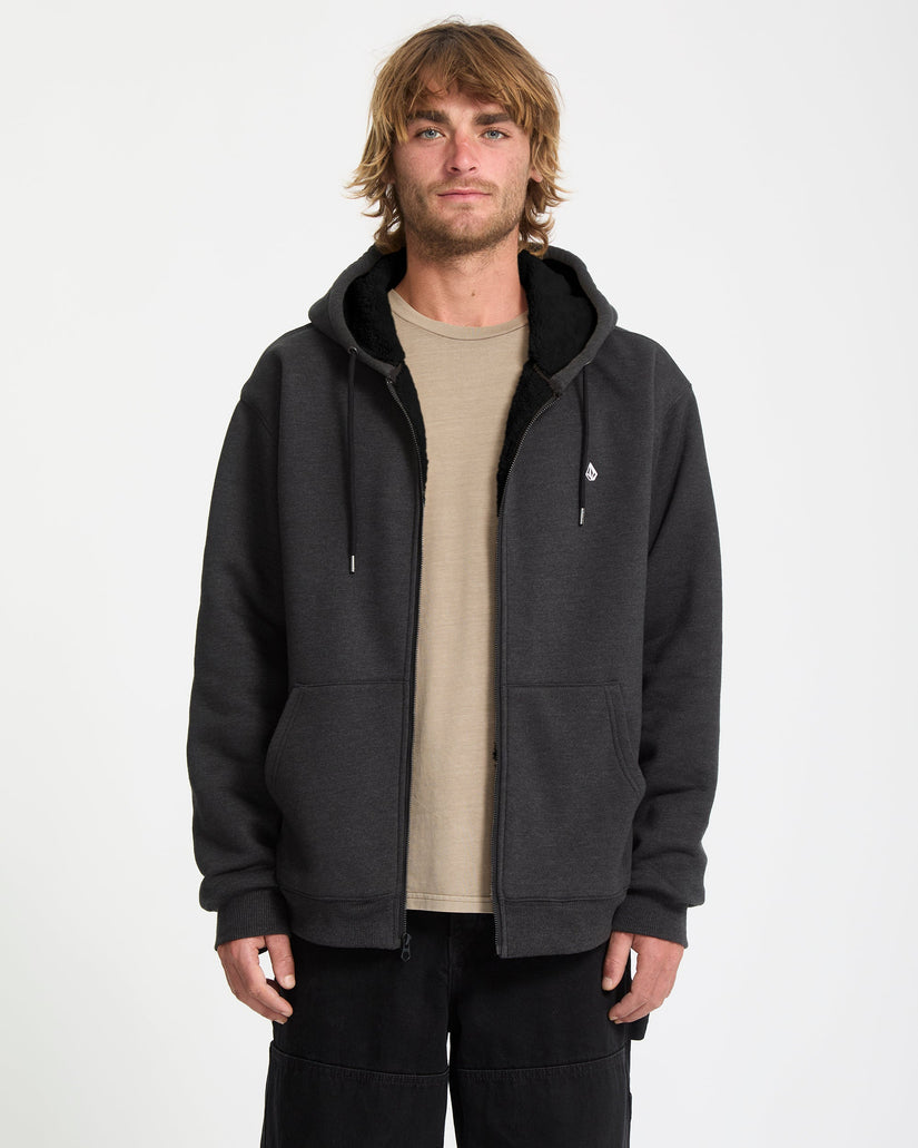 Man wearing a black hoodie with a small logo on a white background