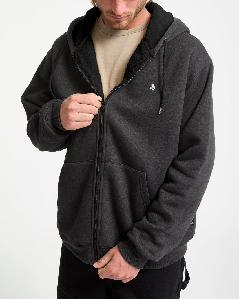 Person wearing a dark gray hoodie with a brand logo on a white background