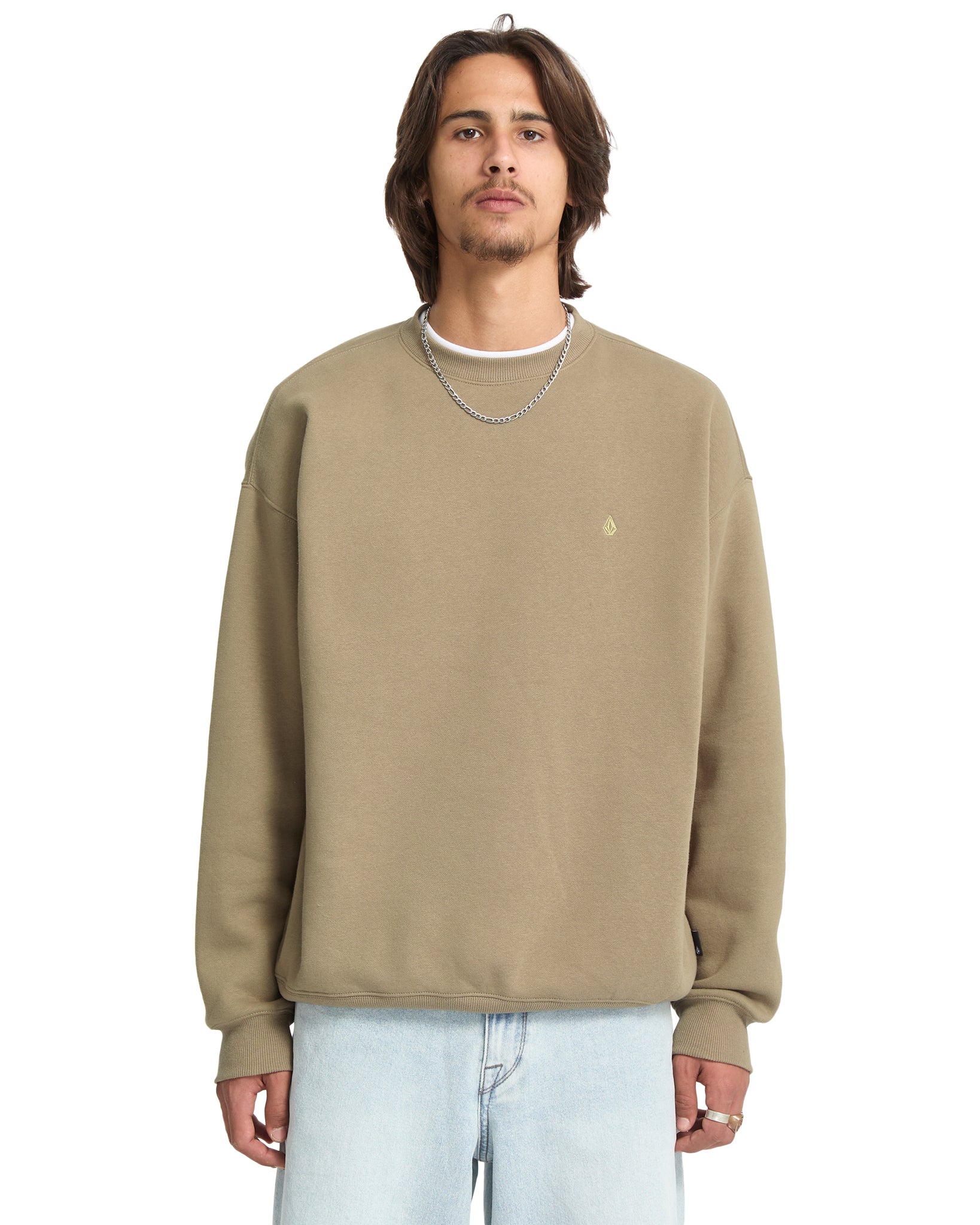 Man wearing a beige sweatshirt with a small logo on a white background