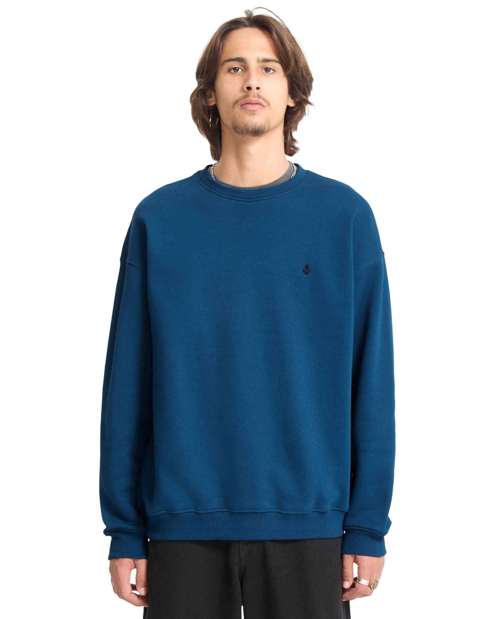 Person wearing a blue sweatshirt with a small logo on a white background