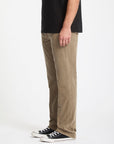 Person wearing brown pants and black shoes on a white background
