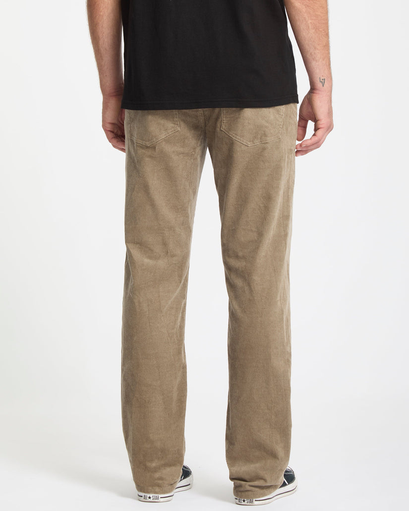 Person wearing brown pants and a black shirt on a white background