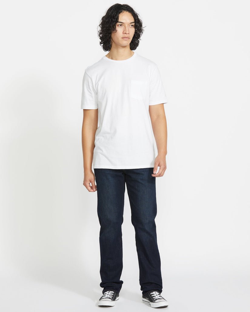 Person wearing a plain white t-shirt and dark jeans on a white background