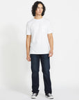 Person wearing a plain white t-shirt and dark jeans on a white background