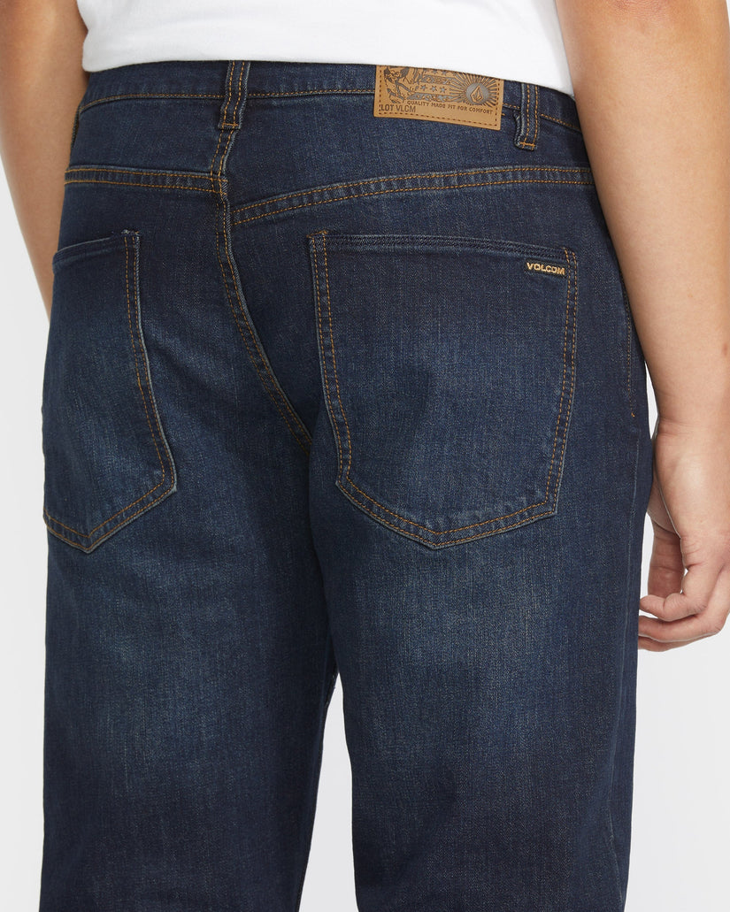 Dark blue jeans with a brand patch on a white background