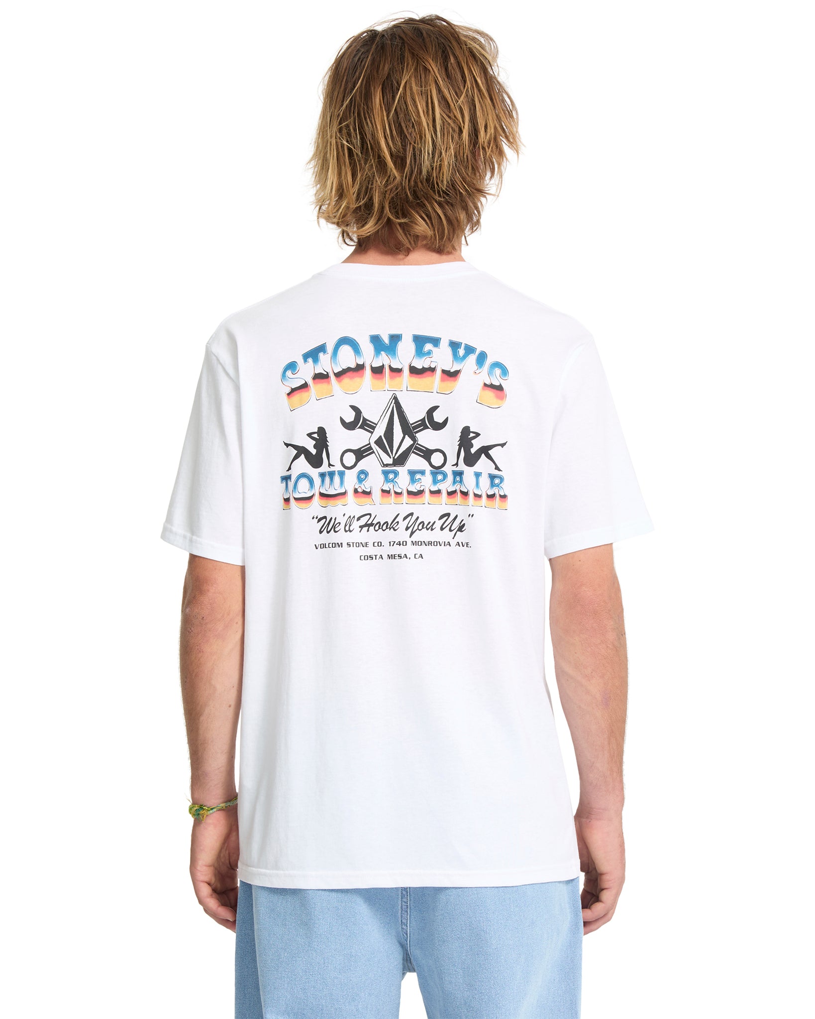 Person wearing a white t-shirt with colorful graphics and text on the back
