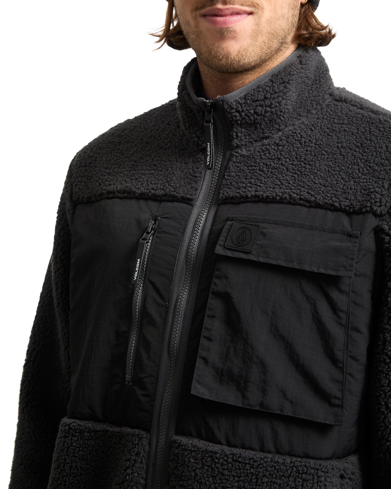 Black jacket with fleece lining worn by a person on a white background