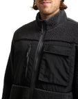 Black jacket with fleece lining worn by a person on a white background