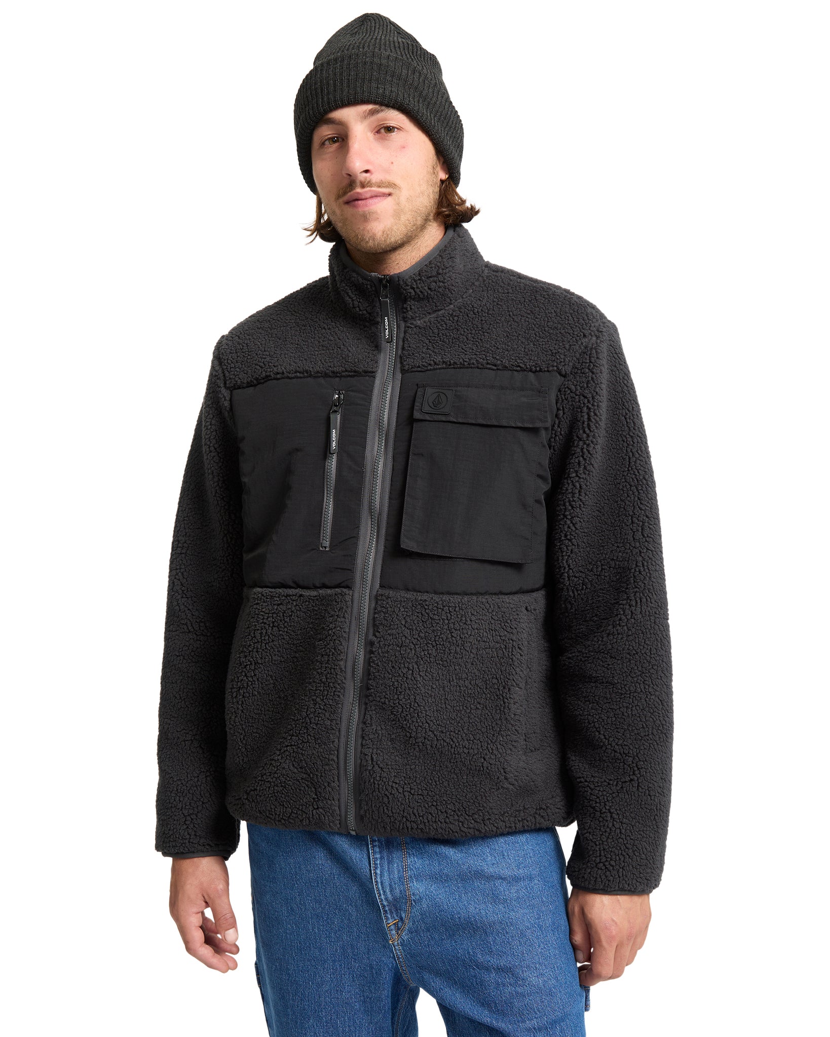 Man wearing a black fleece jacket and beanie on a white background