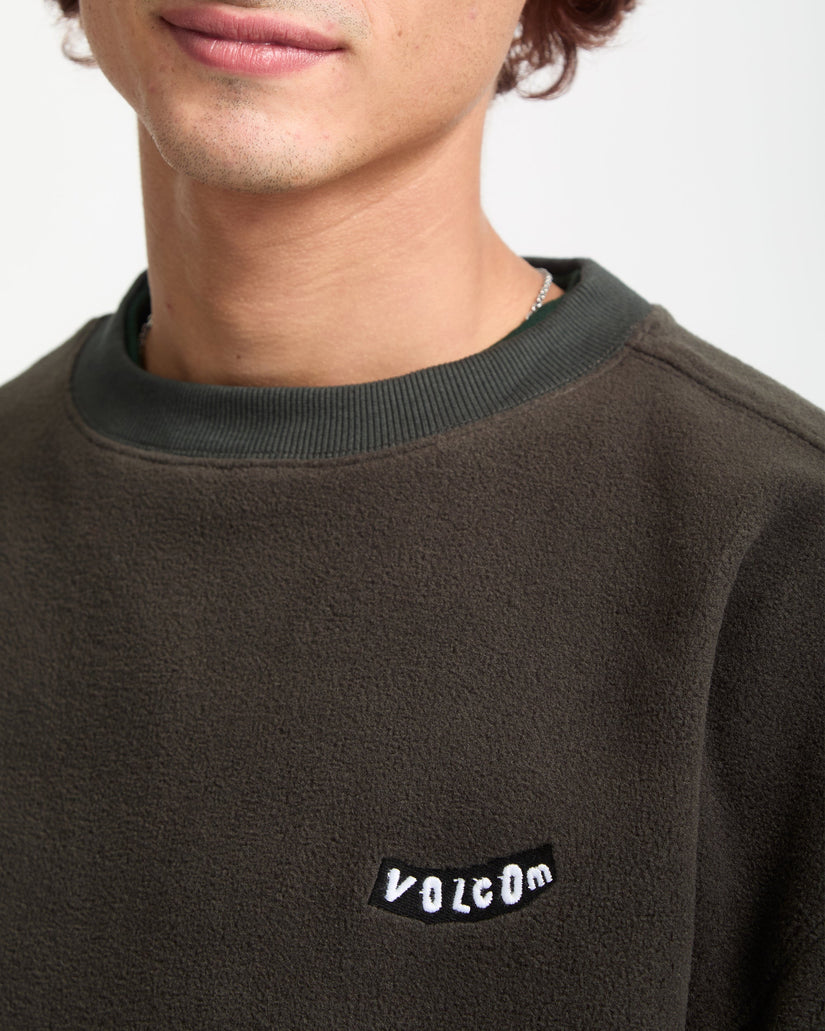 Person wearing a dark brown sweatshirt with Volcom logo