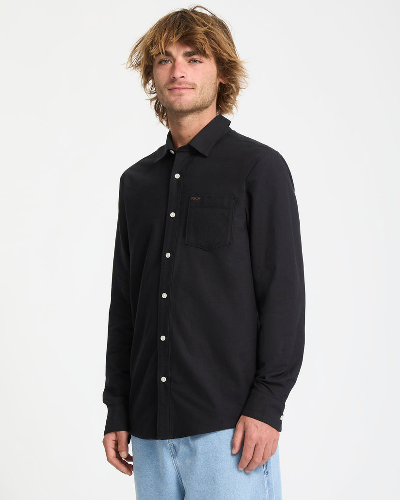 Man wearing a black button-up shirt on a white background