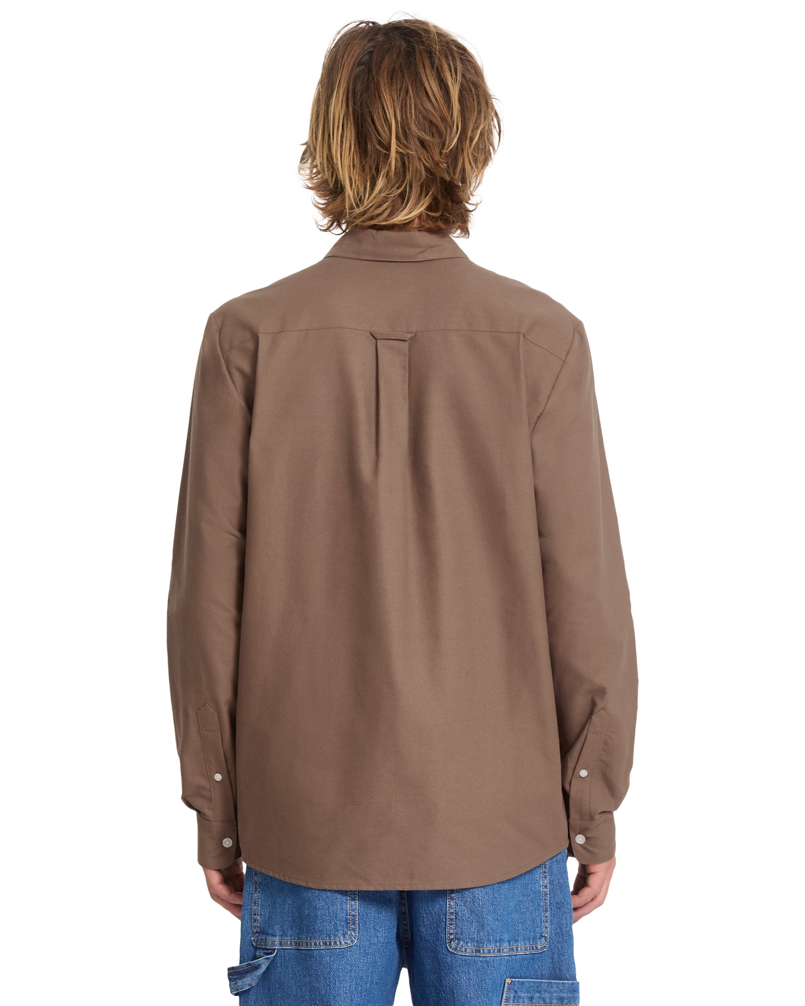 Person wearing a brown jacket and blue jeans on a white background