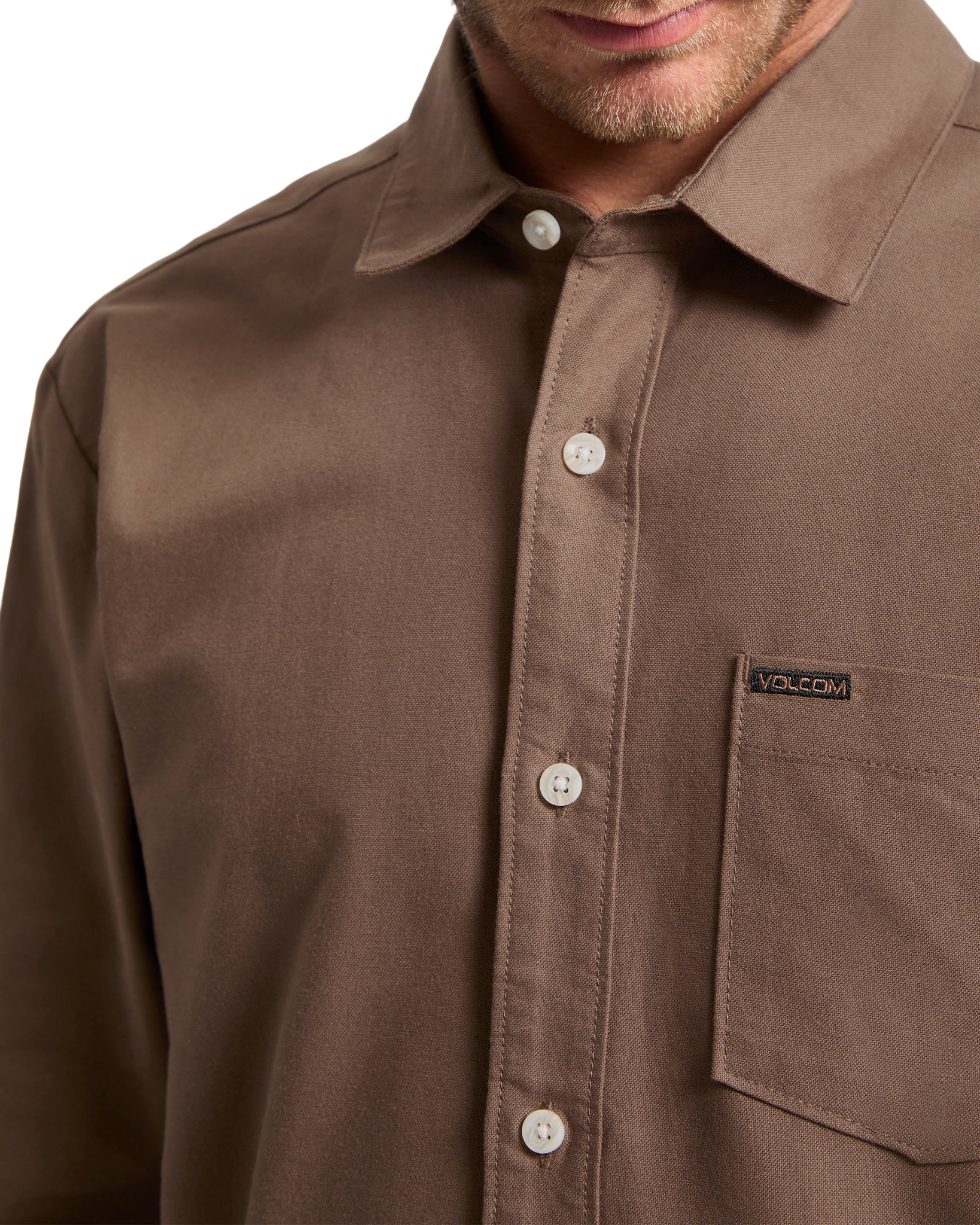 Brown button-up shirt with a Volcom logo on a white background