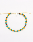 A beaded adjustable cord bracelet featuring repeating small flower motifs in teal, orange, and yellow, with a silver-toned clasp, displayed on a clean white background.