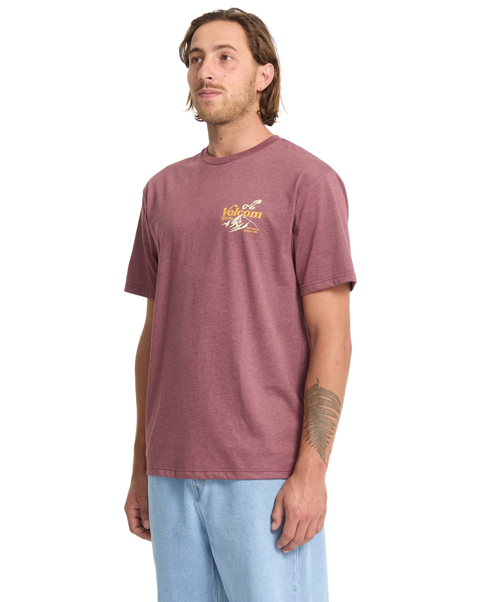 Man wearing a maroon t-shirt with a logo on a white background