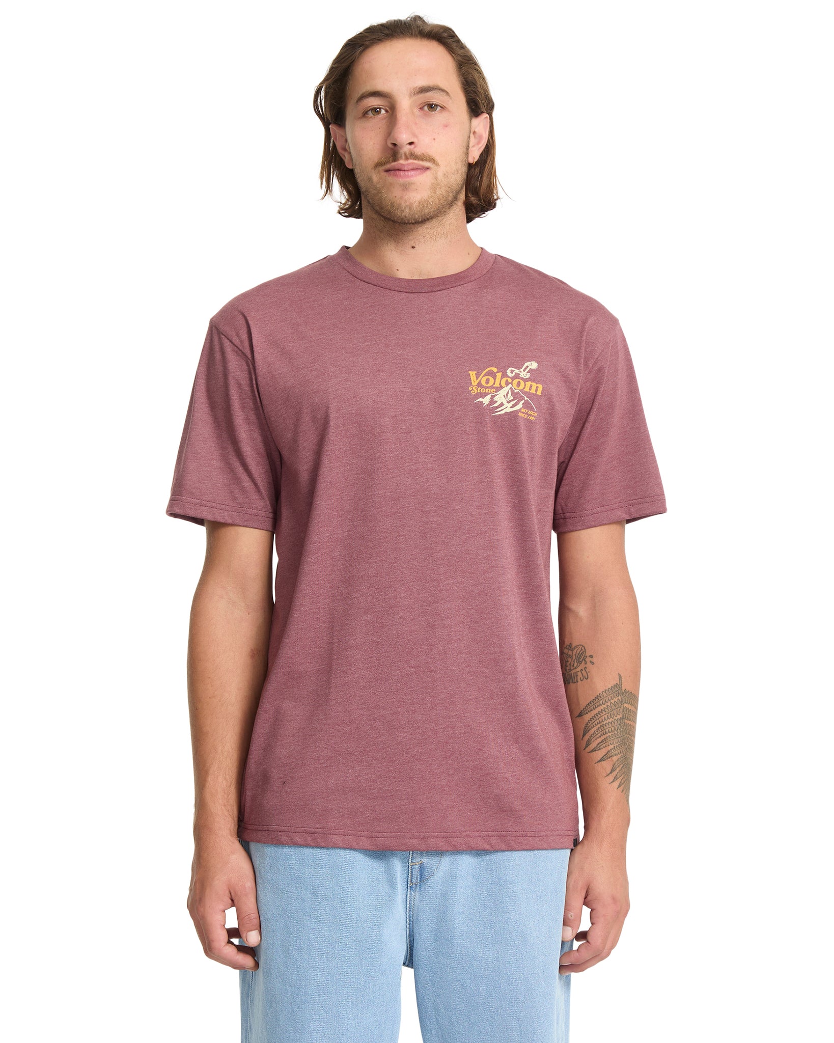 Man wearing a maroon t-shirt with a logo on a white background